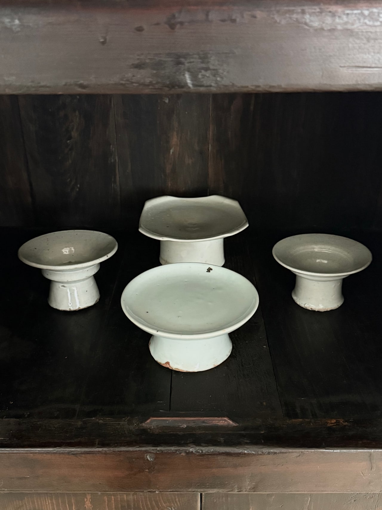 Joseon white porcelain ritual dishes resting on dark wooden furniture